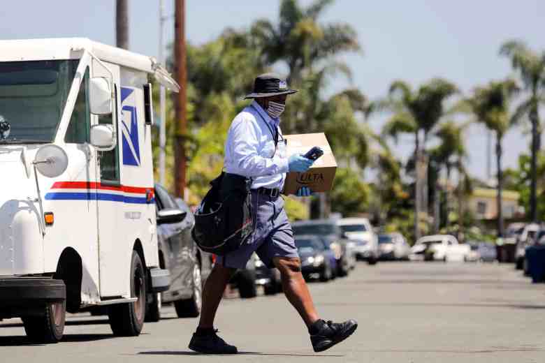 USPS mailman James Daniels carries an Ulta beauty box on his mail delivery route.