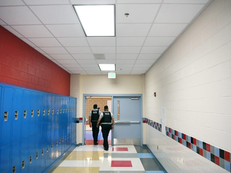 Alexandria Police Department school resource officers walk through a hallway at T.C. Williams High School.