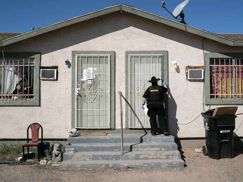 Maricopa County constable Darlene Martinez knocks on a door before posting an eviction order. The CDC eviction moratorium expires June 30, 2021.