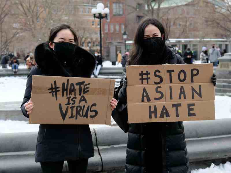 Protestors hold signs at the End The Violence Towards Asians rally in New York City.