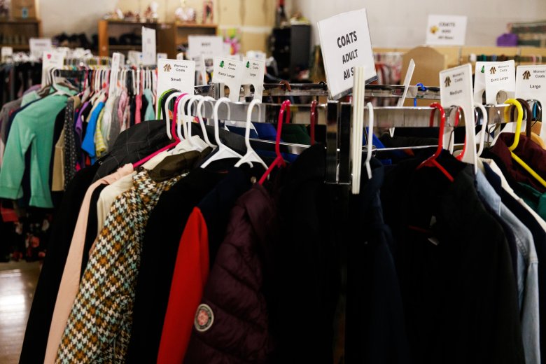 Coats and other clothes are visible on hangers, organized by size.